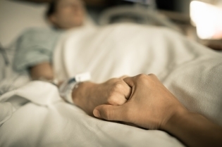 person giving sick loved one support man holding womans hand l